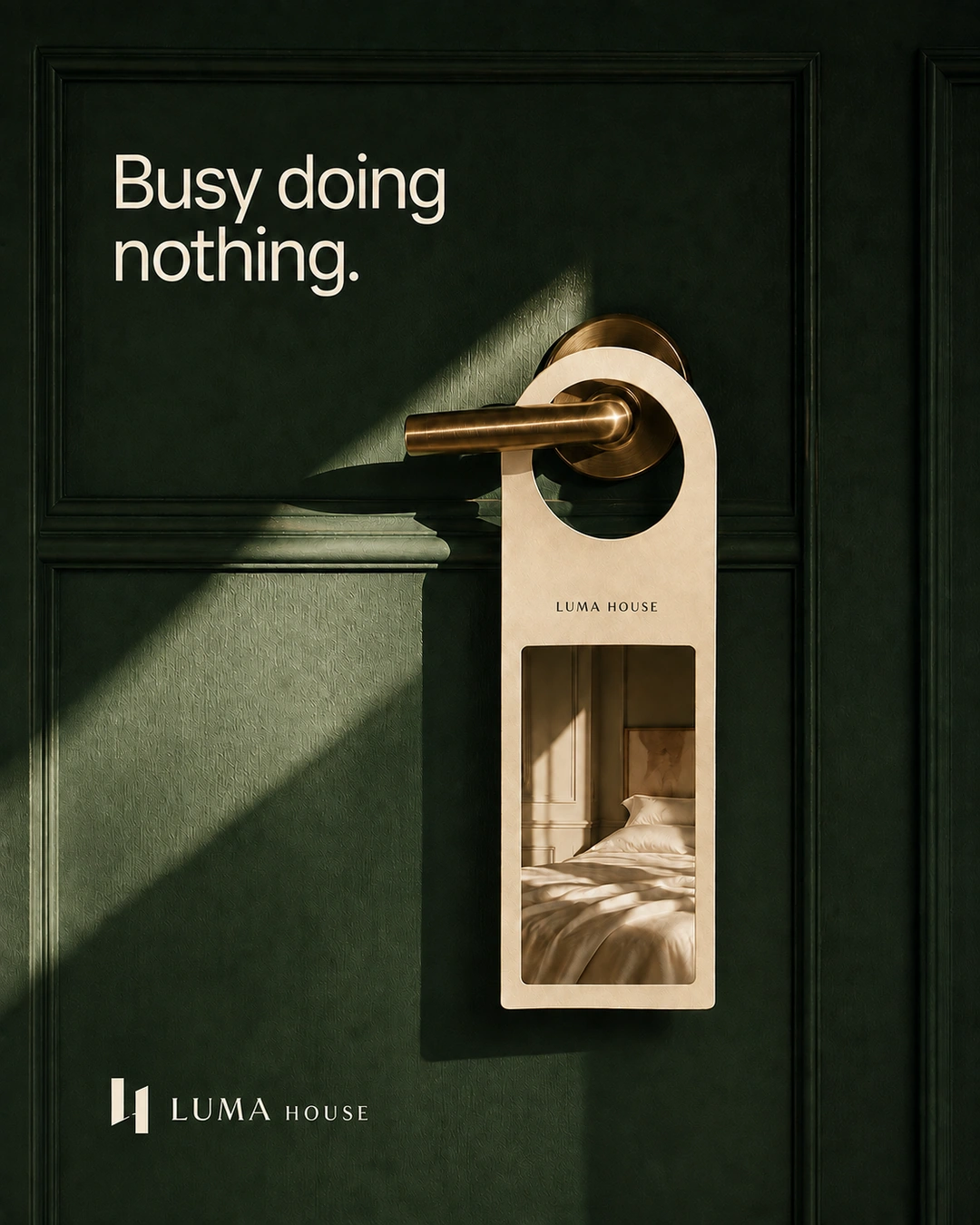 A door hanger on a brass handle opens visually into a quiet bed against a green door.